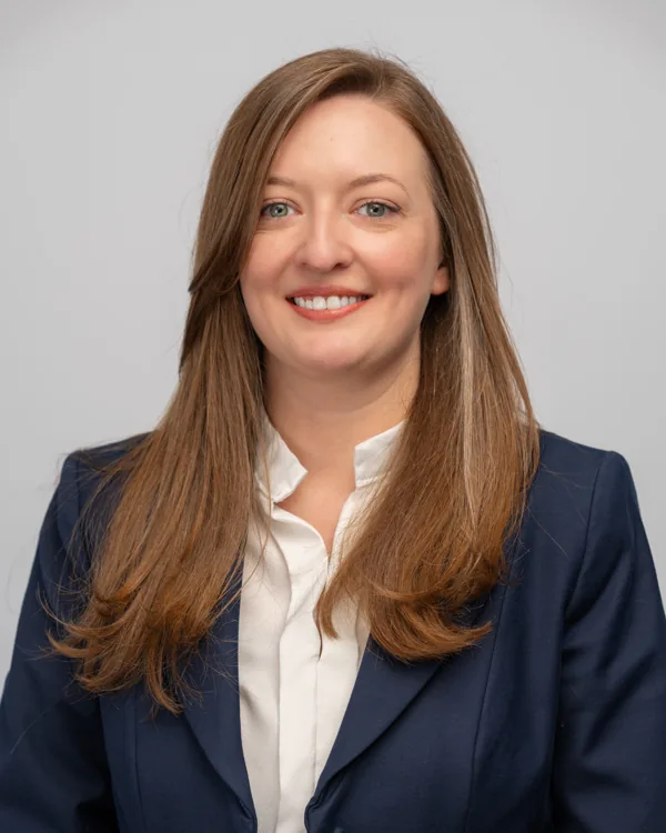 Studio headshot in a navy blazer